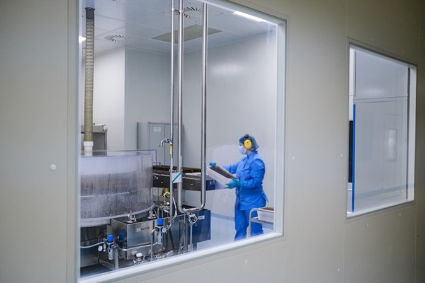 Liquid supplement filling line behind a cleanroom window
